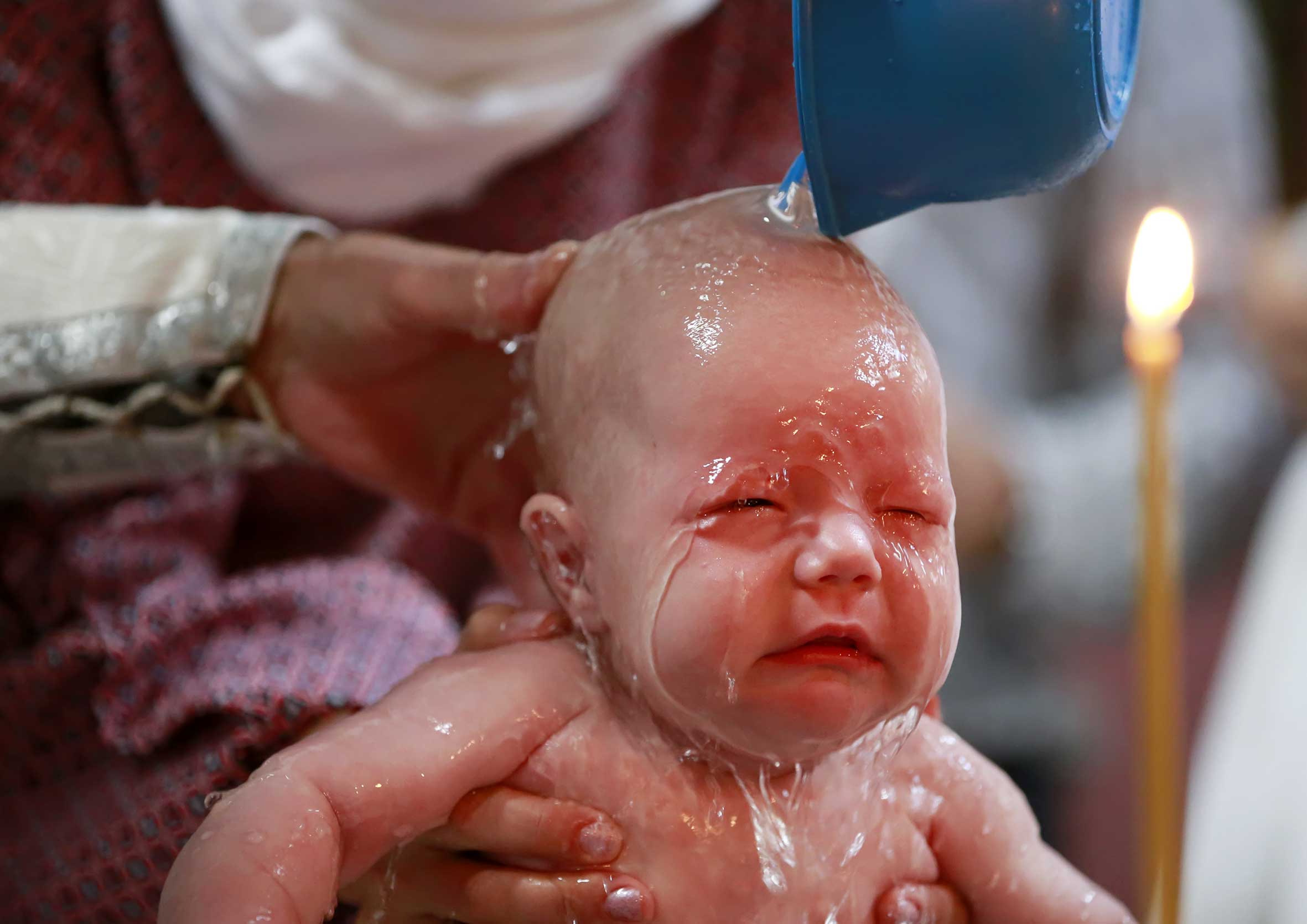 imagen de bebé llorando en su bautizo